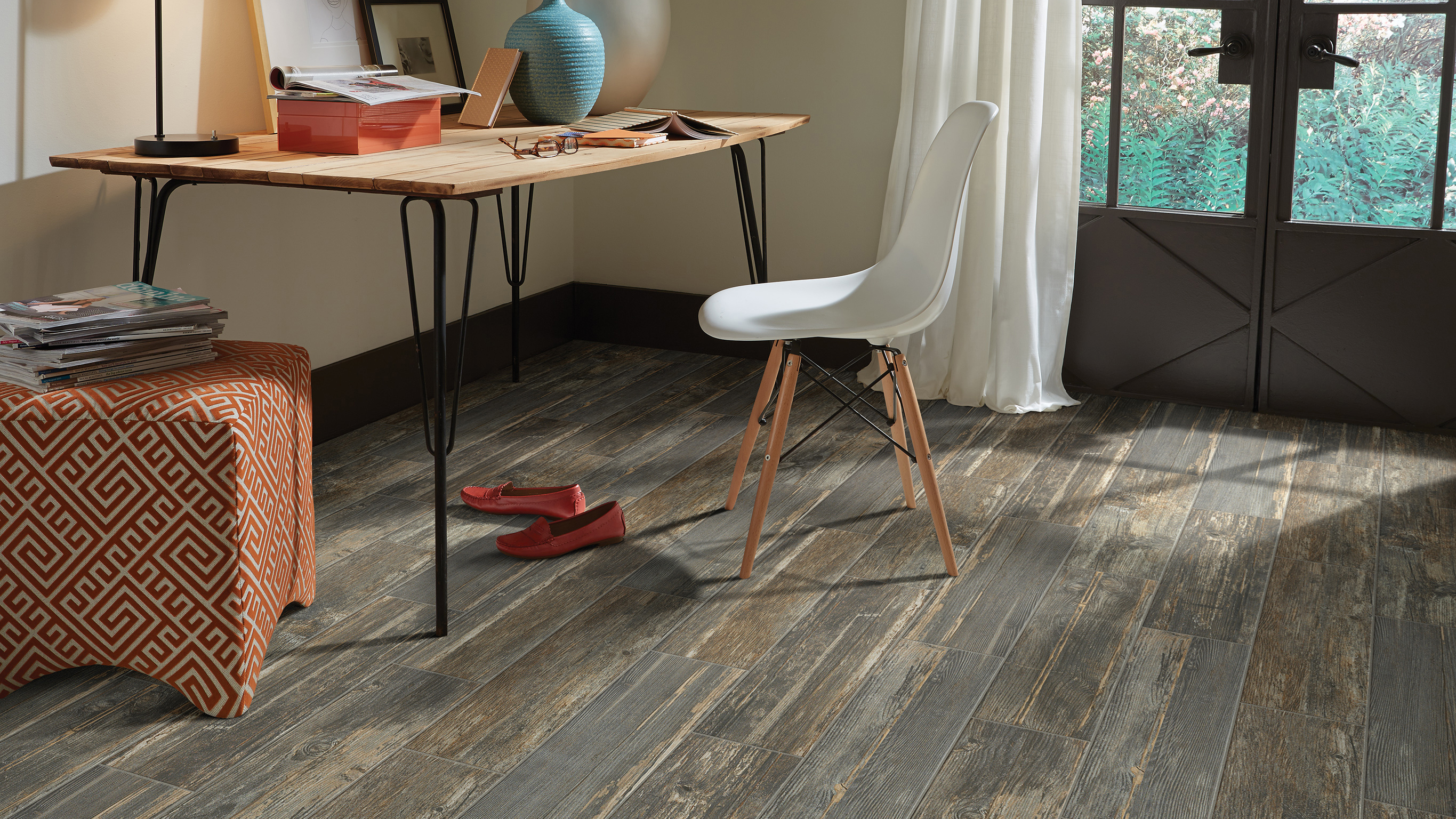 Desk and chair in a living area with wood-look tile on the floor